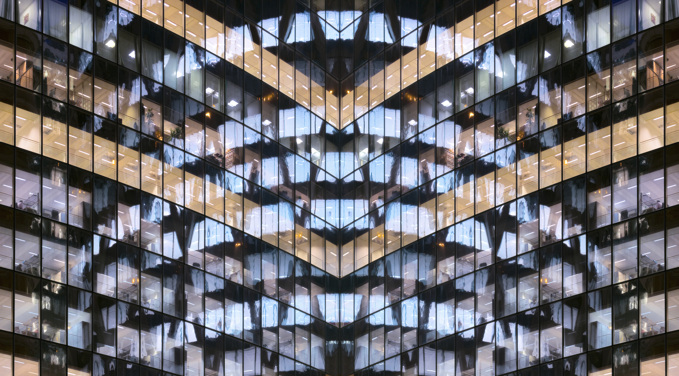 Reflections in glass office facade at dusk