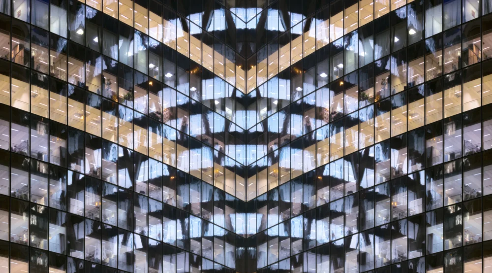 Reflections in glass office facade at dusk