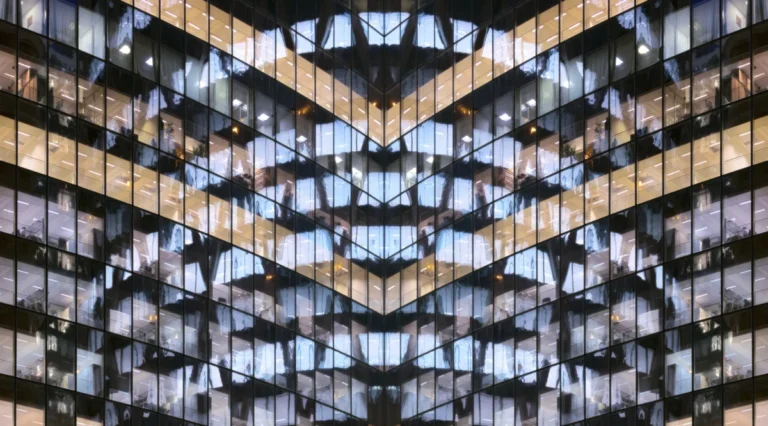 Reflections in glass office facade at dusk