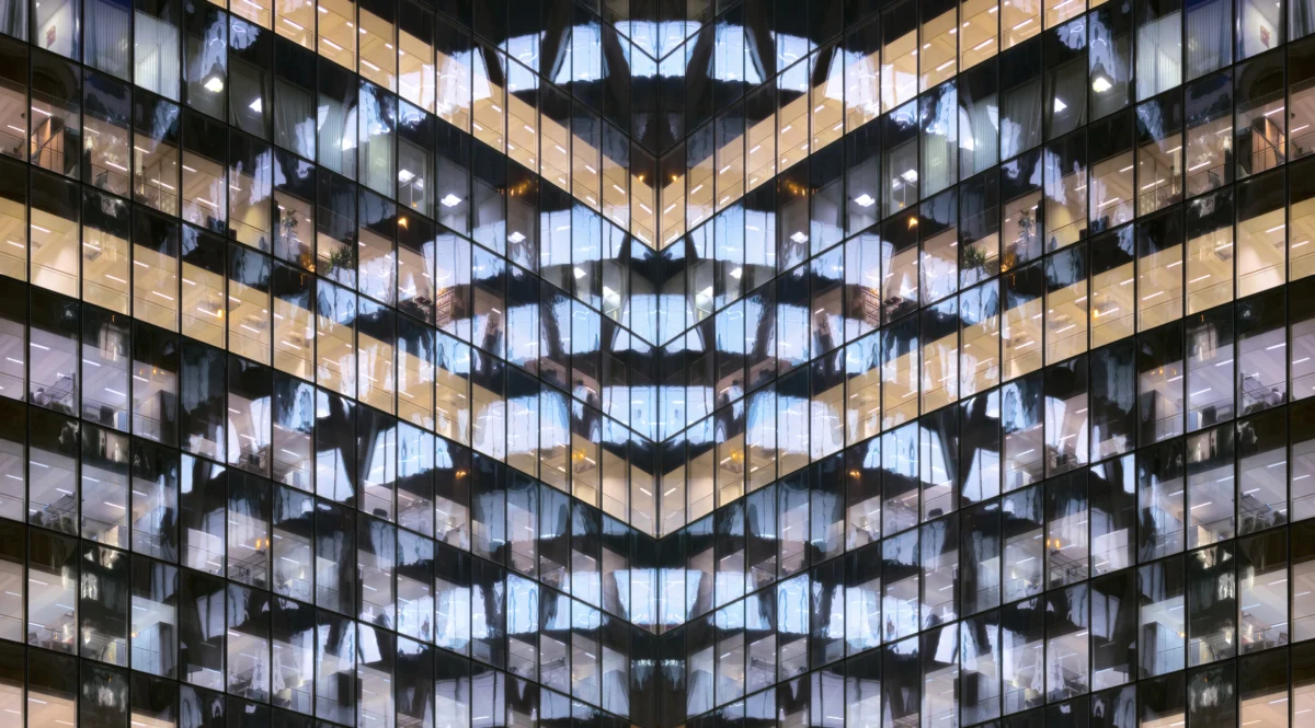 Reflections in glass office facade at dusk