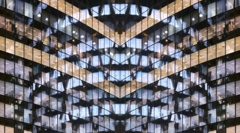Reflections in glass office facade at dusk