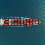 Aerial view of cargo ships in containers sailing in the sea.