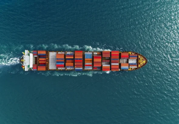 Aerial view of cargo ships in containers sailing in the sea.