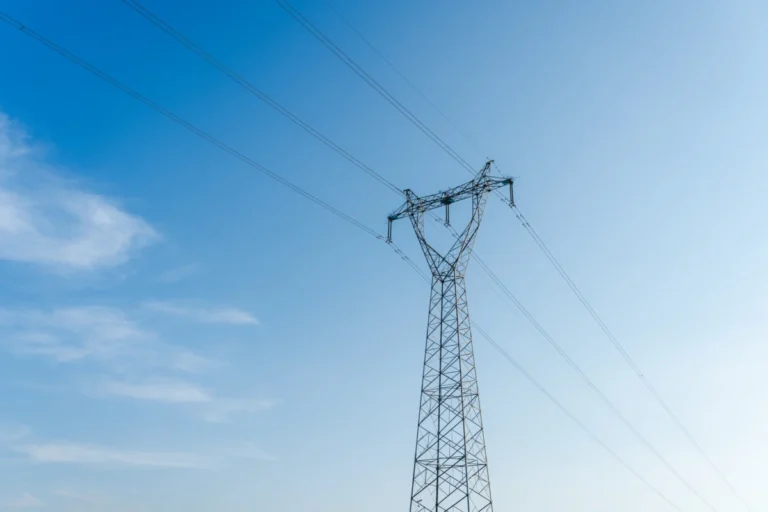 High voltage transmission tower under clear blue sky