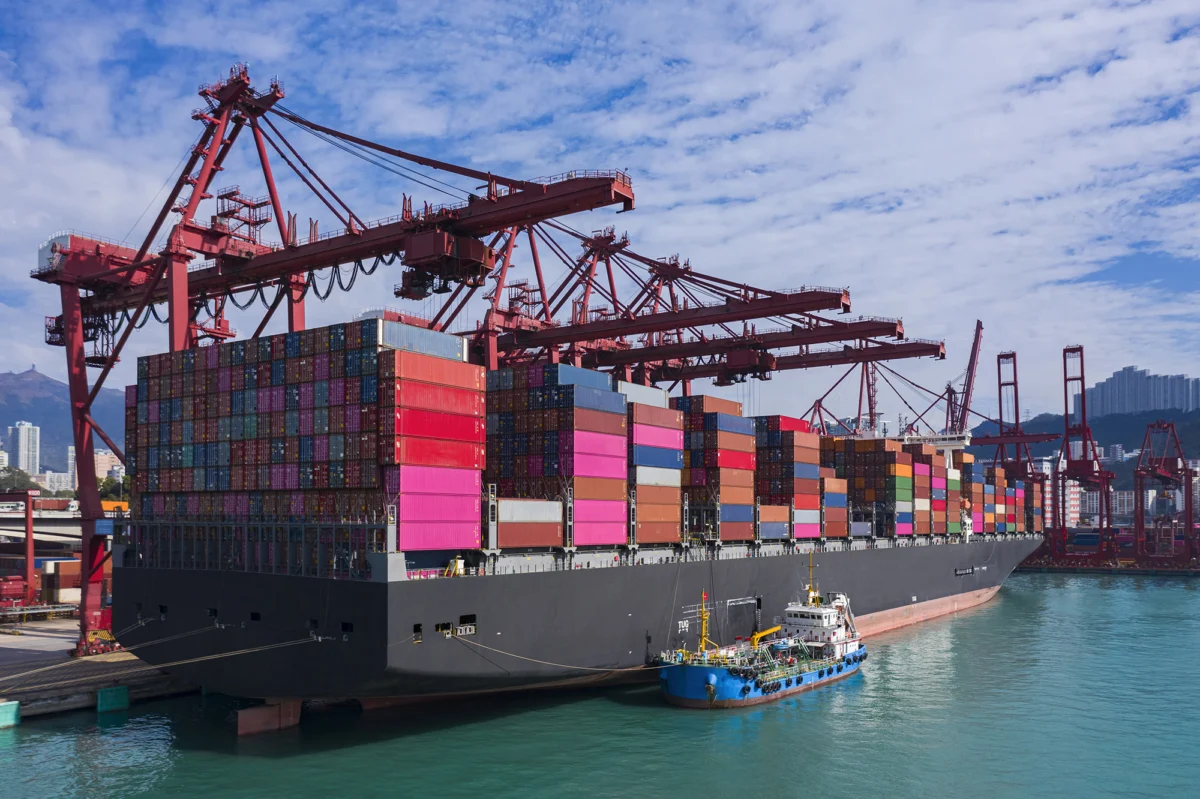 Container cargo ship at Terminal commercial port and working crane bridge loading container for business logistics, import export, shipping or transportation.