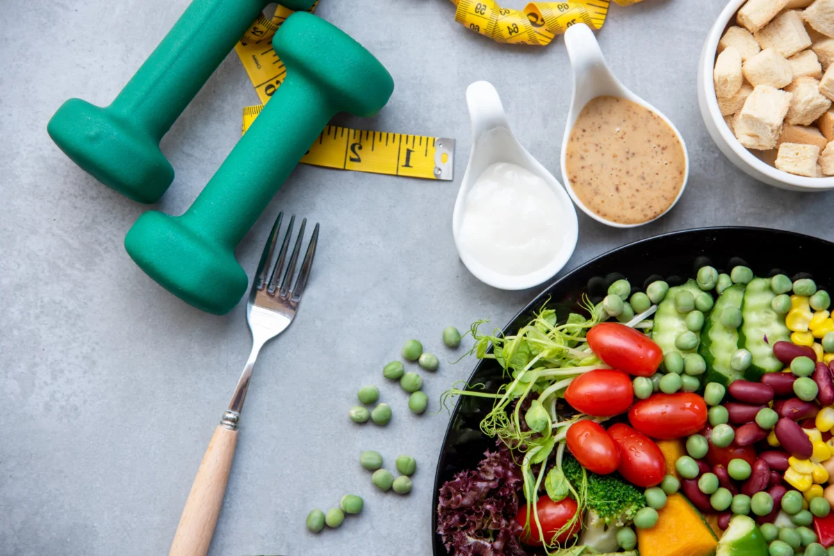 Diet Healthy food and lifestyle health concept. Sport exercise equipment workout and gym background with nutrition detox salad for fitness style. Healthy Concept