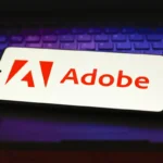 In this photo illustration, the Adobe Inc. logo is displayed