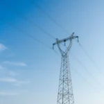 High voltage transmission tower under clear blue sky
